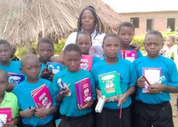 Sharlotte Niwagaba (center) after handing over scholastic materials to vulnerable children in Kijura Town Council