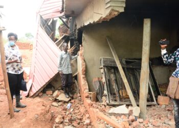 Minister Nabakooba inspecting one of the destroyed houses in Kitende