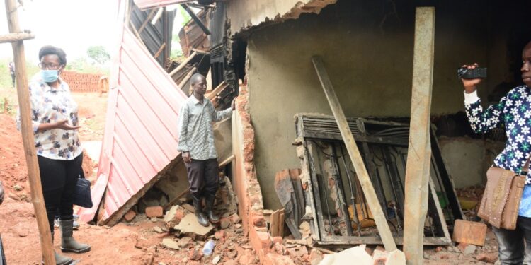 Minister Nabakooba inspecting one of the destroyed houses in Kitende