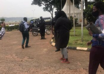 Carol Birungi putting on red slippers