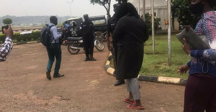 Carol Birungi putting on red slippers