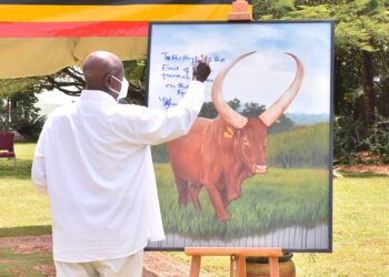 President Yoweri Museveni writing a message to the Emir of Quatar on a painting of an Ankole Cattle with, this was after with NARO officials lead by the President’s Special Envoy Amama Mbabazi a meeting on how to Fatten the local Cattle so as to earn financially on the international market, the meeting took place at State House Entebbe on 15th March 2022. Photo by PPU/Tony Rujuta.