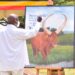 President Yoweri Museveni writing a message to the Emir of Quatar on a painting of an Ankole Cattle with, this was after with NARO officials lead by the President’s Special Envoy Amama Mbabazi a meeting on how to Fatten the local Cattle so as to earn financially on the international market, the meeting took place at State House Entebbe on 15th March 2022. Photo by PPU/Tony Rujuta.