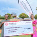 Tyra Abok receives a dummy cheque of USD1500 from Ruparelia Foundation