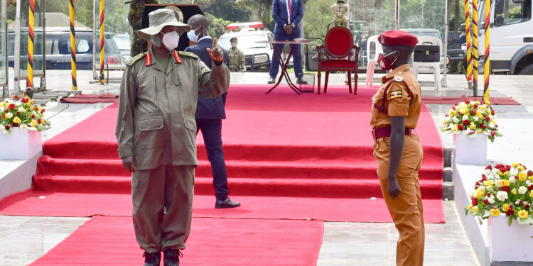 President Museveni talks to Gassi Christine one of the best female students during the pass out at Kololo on Friday. PPU Photo 01