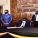 Ngoga signs in the condolence book as the Speaker and Deputy Speaker of Parliament of Uganda look on