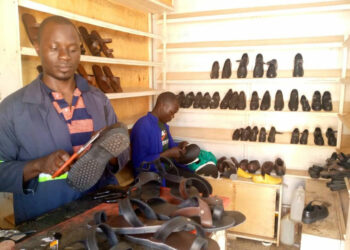 Simon Musisi Wesonga nga agatta engatto mu kkampuni ye eya WESOM SHOES LTD