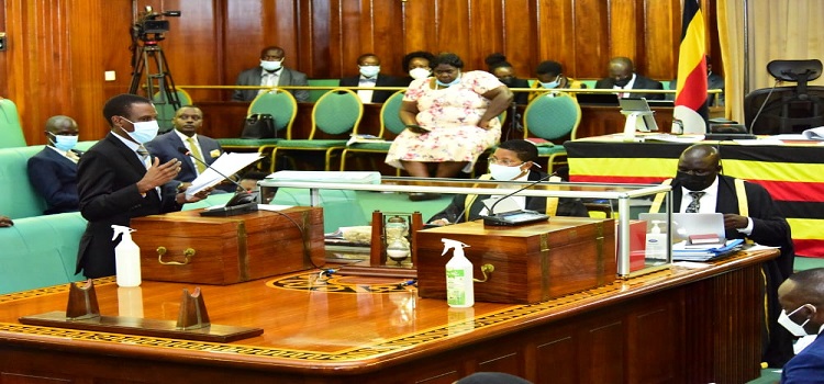 Kiryowa Kiwanuka (standing) makes his point during the committee stage of processing of the bill