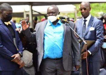 Oulanyah's brother Francis Emanu with Andrew Ojok (putting on a bow tie).