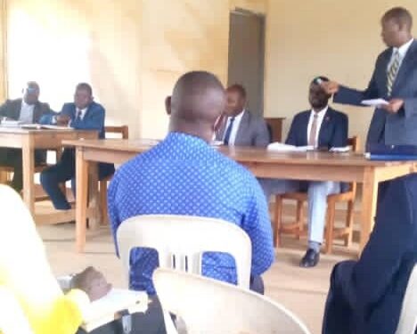 Kagadi Deputy Resident District Commissioner Tumusiime, DISO in a meeting with district councilors and other officials