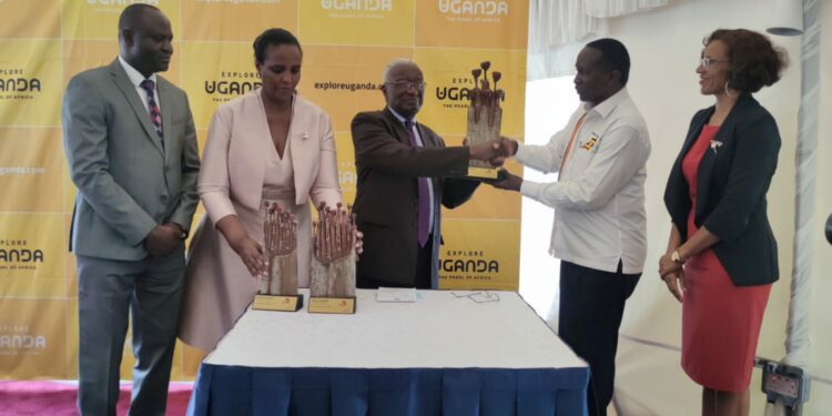 L-R: Basil Ajer, Director of Tourism at MTWA, UTB Chairperson Mrs. Susan Muhwezi, Hon Tom Butime, the Minister of Tourism, Wildlife and Antiquities receiving the award from UTB board Chairman Hon. Daudi Migereko, UTB CEO Lily Ajarova.