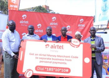 An Airtel representative (c) activating merchant Till number for small business owners at  Nakawa market. This was at the announcement of the addition of the Merchant Till Number for small businesses feature on Airtel Money.