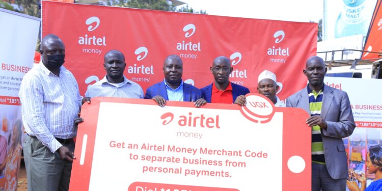 An Airtel representative (c) activating merchant Till number for small business owners at  Nakawa market. This was at the announcement of the addition of the Merchant Till Number for small businesses feature on Airtel Money.