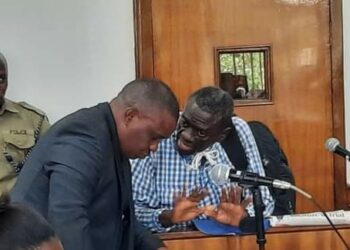 Dr Kizza Besigye with one of his lawyers Erias Lukwago in Court
