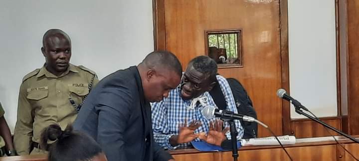 Dr Kizza Besigye with one of his lawyers Erias Lukwago in Court