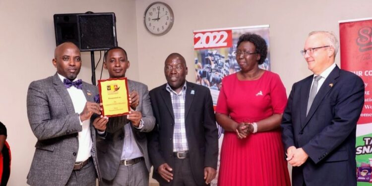 Dr Lawrence Muganga (left) receiving his Award