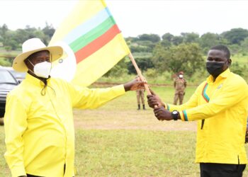 President Yoweri Museveni handing the party flag to Andrew Ojok