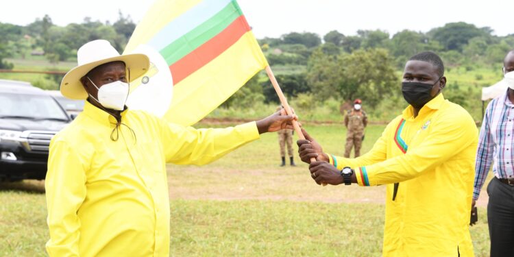 President Yoweri Museveni handing the party flag to Andrew Ojok