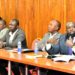 Lawyer Richard Buzibira (R) responding to questions from the committee as his partner, Kyle Lubega (2nd, R) gets lost in thought