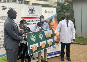 Habitat Director Robert Otim and Dr John Sekabira with parents of twins at Mulago June 15, 2022