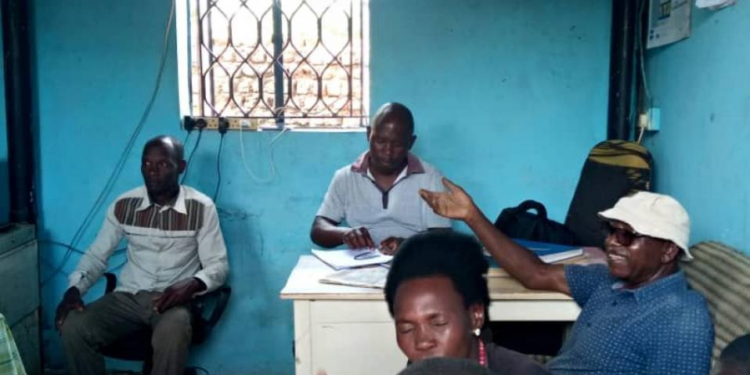 Arthur Mujuni with complainants at Gerenge police post