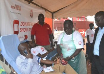 The Chief Guest Deputy Resident City Commissioner Jinja Mr Mike Ssegawa (Right) talking to the Uganda Blood Bank and Red Cross team during the donation of the blood drive by Nile Breweries Limited