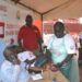 The Chief Guest Deputy Resident City Commissioner Jinja Mr Mike Ssegawa (Right) talking to the Uganda Blood Bank and Red Cross team during the donation of the blood drive by Nile Breweries Limited