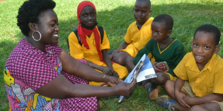 One of the Rotarians with pupils in group reading through the story books they donated to the pupils of Spire Road Primary School .PHOTO BY ANDREW ALIBAKU