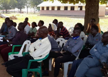 Headteacher, Ekunyu seated with some of his staff in th meeting with district officials