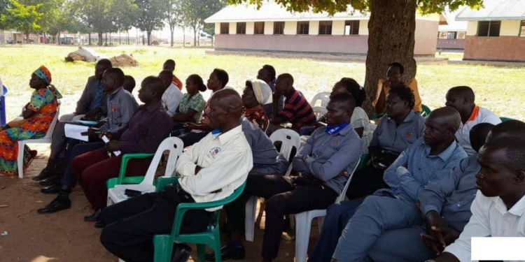 Headteacher, Ekunyu seated with some of his staff in th meeting with district officials