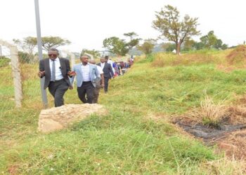 Dr. Omagino leads MPs on the committee on a tour of the land at Naguru