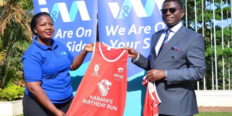 Buganda Kingdom Katikkiro Charles Peter Mayiga hands over kits to
I&M Bank’s Ronnie Zalwango.