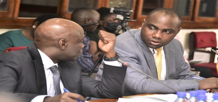 Hon. Henry Musasizi (R) was put to task to explain government's interest in buying shares in Roko Construction Ltd