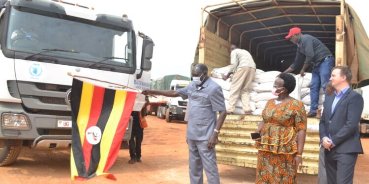 The Minister for Relief, Disaster Preparedness and Refugees, Mr Hilary Onek (left) and Napak District Woman MP Faith Nakut flag off relief food to Karamoja at Office of the Prime Minister stores in Namanve, Wakiso District on July 19, 2022. Courtesy Photo