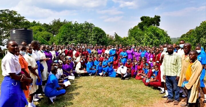 Students from Tororo Girls School pose for a photo after touring Kawumu Presidential Farm in Luwero district on Friday. (Standing R) are staff of the farm