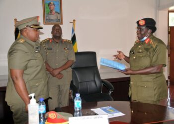 Brig Gen Agnes Musoke (R) preparing to handover instruments of office to Lt Col Betty Musuya (L) as Brig Gen Ssebugwawo (C) Looks on.