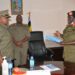 Brig Gen Agnes Musoke (R) preparing to handover instruments of office to Lt Col Betty Musuya (L) as Brig Gen Ssebugwawo (C) Looks on.