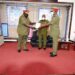 Gen Wilson Mbadi looks on as Lt Gen Andrew Gutti (L) handsover a report to Maj Gen Igumba
