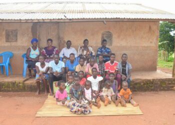 Birungi Malirweki, 56 (2nd from the right in the back row) and her family at their home in Nyakatehe 2 village, Kyangwali Sub County in Kikuube District, South Western Uganda.