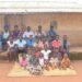 Birungi Malirweki, 56 (2nd from the right in the back row) and her family at their home in Nyakatehe 2 village, Kyangwali Sub County in Kikuube District, South Western Uganda.