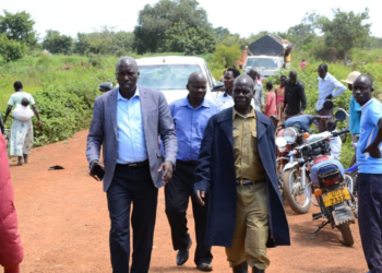 Leaders with police officer along the road where traders lost lives