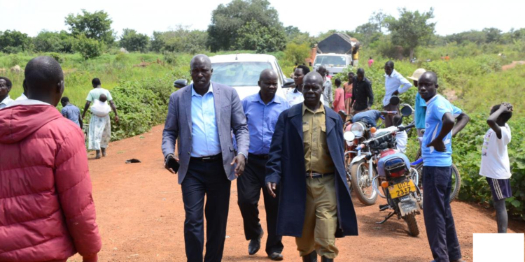 Leaders with police officer along the road where traders lost lives