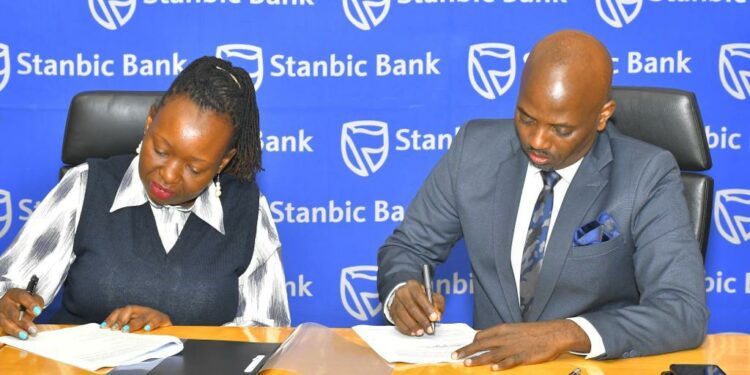 Stanbic Bank Executive Director Emma Mugisha with Victoria University Vice Chancellor Dr Muganga signing the deal