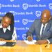 Stanbic Bank Executive Director Emma Mugisha with Victoria University Vice Chancellor Dr Muganga signing the deal