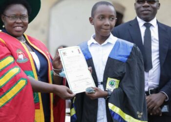 Minister Kaducu handing over a certificate to one of the successful youth under the DIT program