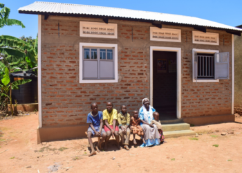 PHOTO: Jesca Magemeso, 58, poses for a family portrait with members of her household in front of their home in Buwaiswa Village, Buwaaya Sub- County, Mayuge District