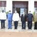 Col. Tom Butime (in black) standing next to President Yoweri Museveni at State House