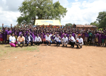 Pupils of Oleni Primary School in a group photo with URSB staff and Partners during the handover of the health and sanitation facility.