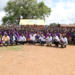 Pupils of Oleni Primary School in a group photo with URSB staff and Partners during the handover of the health and sanitation facility.