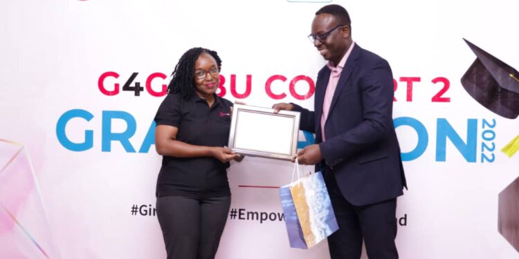 Post Bank Uganda CEO Julius Kakeeto hands over a special plaque and gift to Esther Bwaku for her outstanding role the Girls for Girls second cohort Leader and Chief Mobiliser in the Bank.